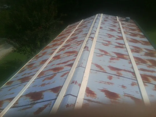 Rusted metal roof panels with new wood purlins before replacement — Storm Damage Roof Repair in Ozone Park by Roofing Brothers