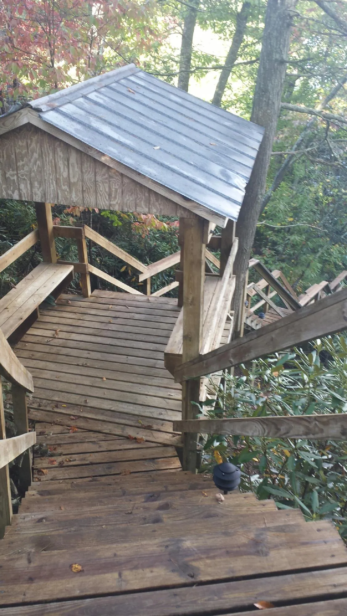 Metal roofed shelter over wooden steps on a wooded walkway — Skylight Repair & Installation work by our crew in Ozone Park