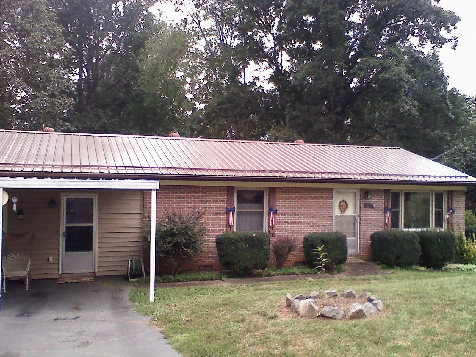 Bronze metal roof and carport on a brick ranch home — Roof Repair work by our crew in Ozone Park